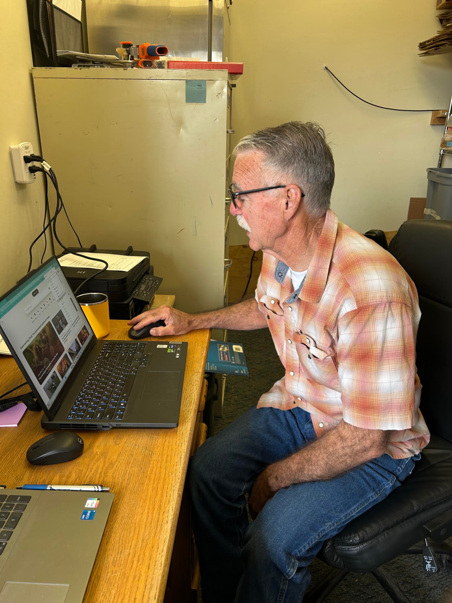 A volunteer working at a laptop in the pantry office