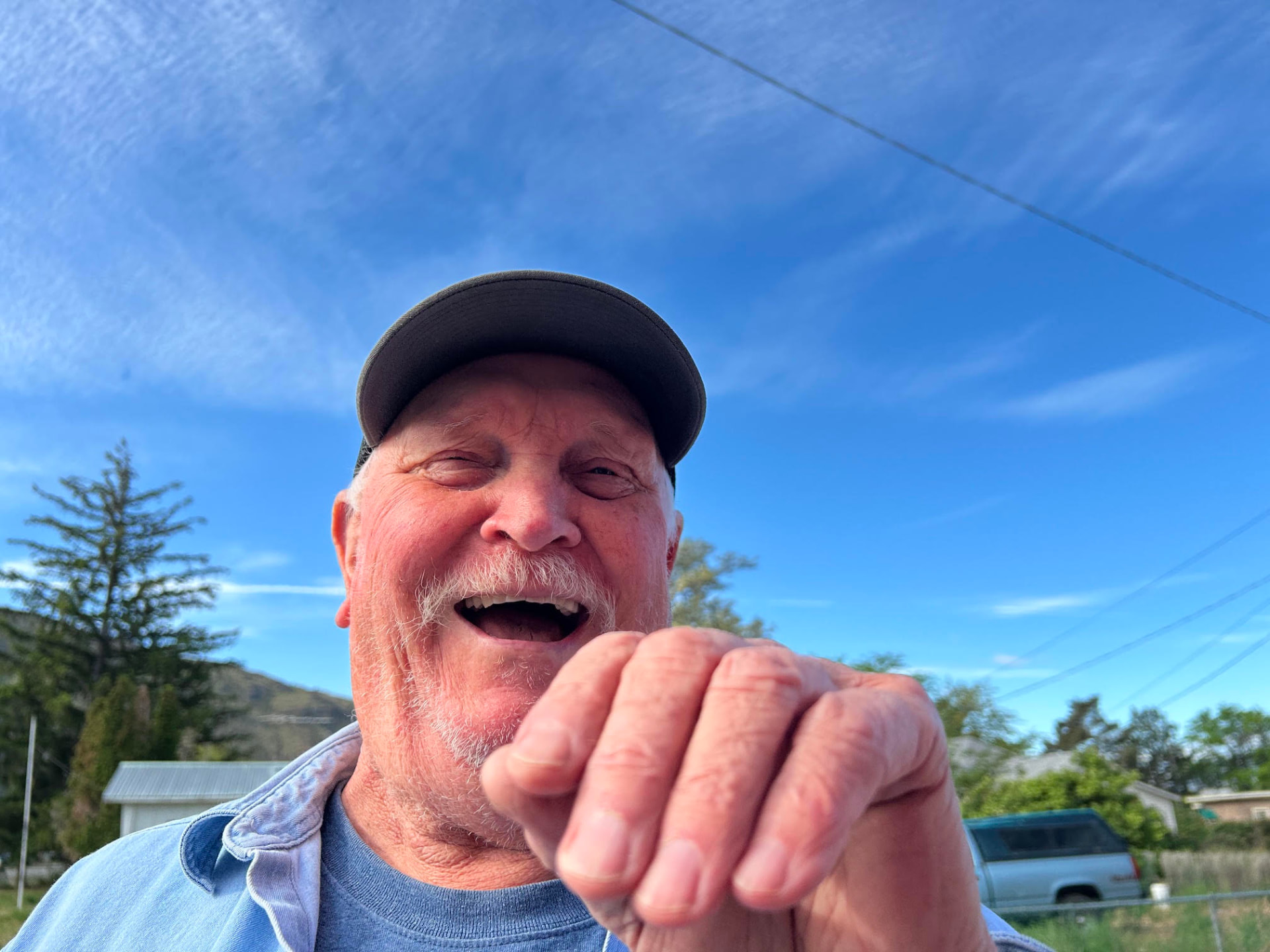 A longtime pantry volunteer smiling outdoors on a sunny day in Brewster